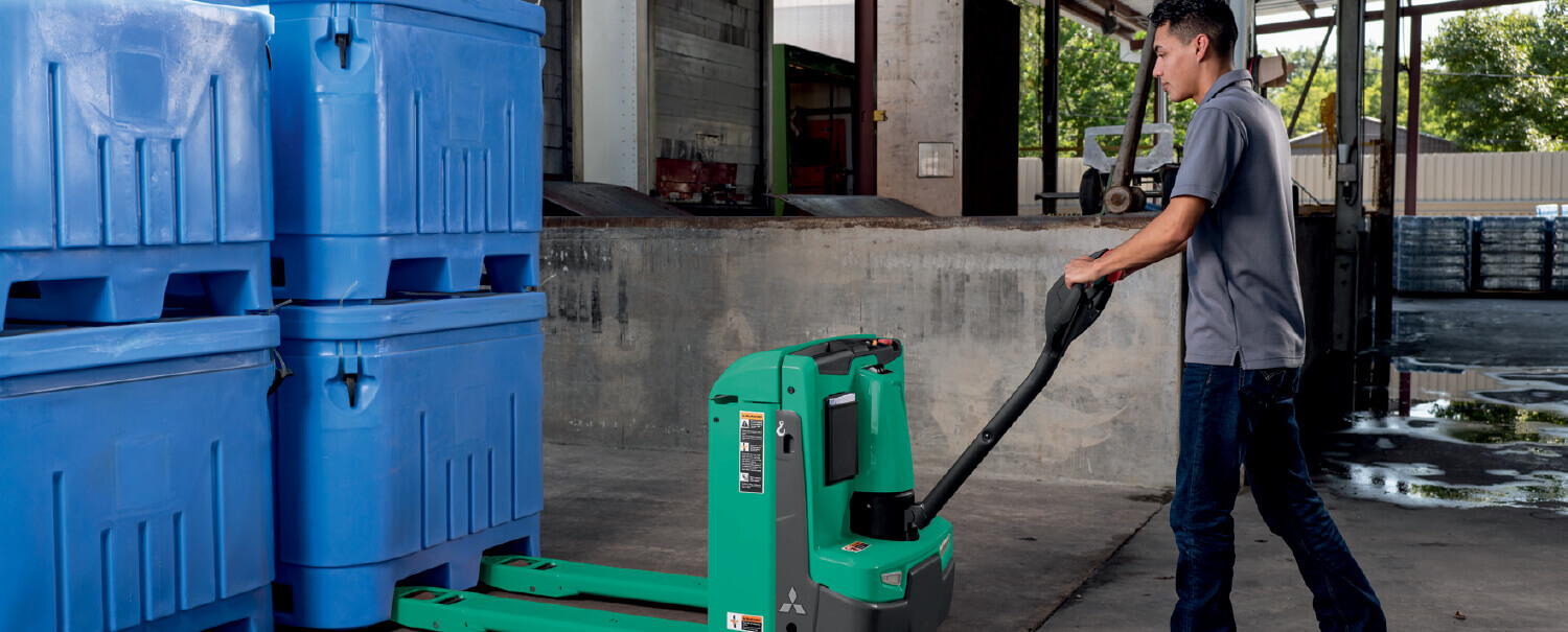 Man about to load blue bins on a Mitsubishi walkie pallet truck